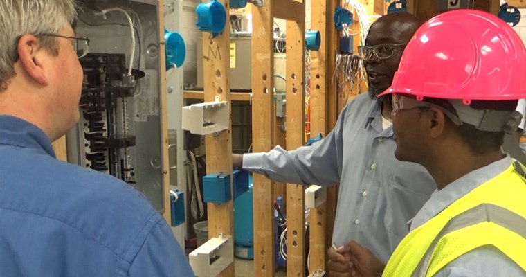 Casey Carwile, personnel director for Design Electric, visits with students in an electricians class at Buckingham Correctional Center